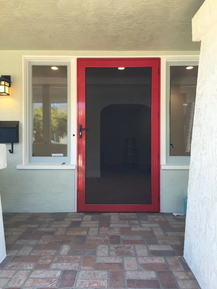 Front door with red security screen door installed.