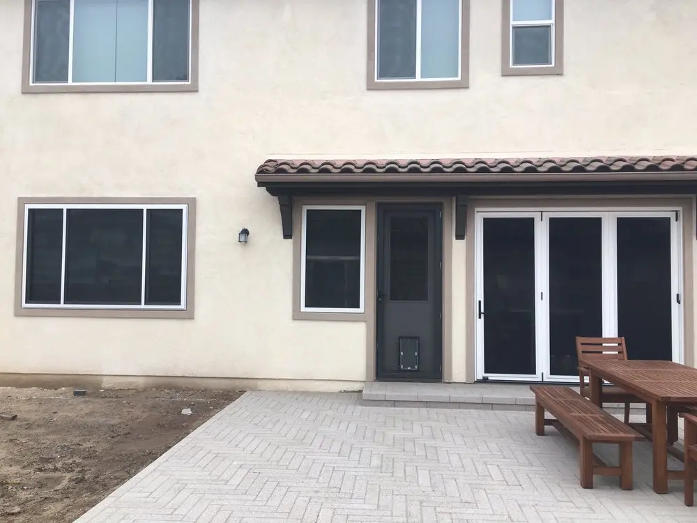 Modern home with security screen door and windows.